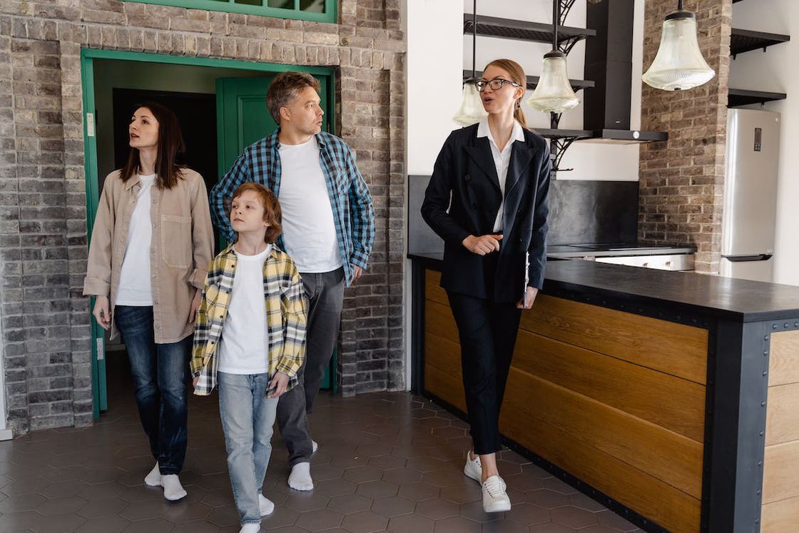 Real estate agent showing a property to a family